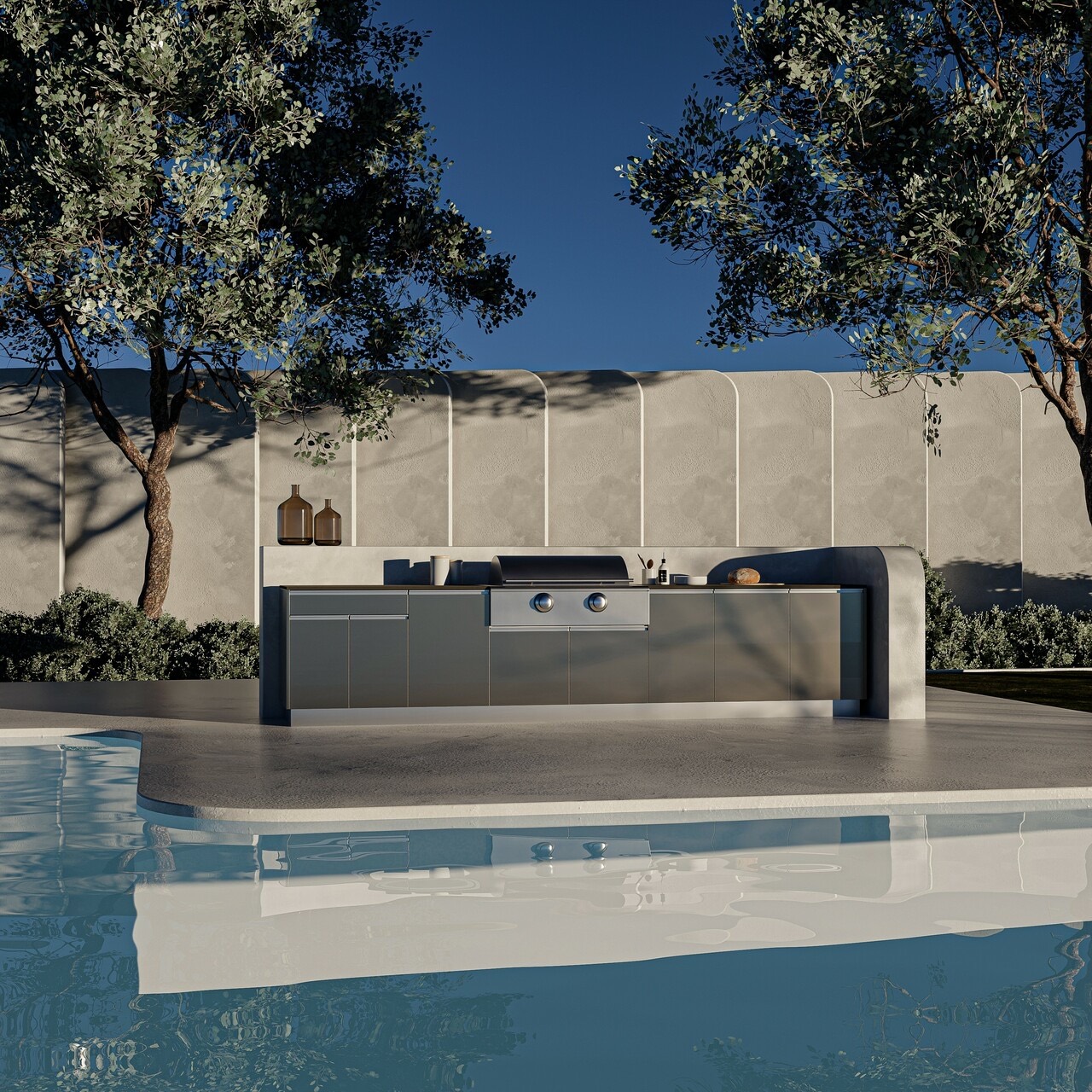Graphite outdoor kitchen set into a curved concrete wall beside a pool at dusk
