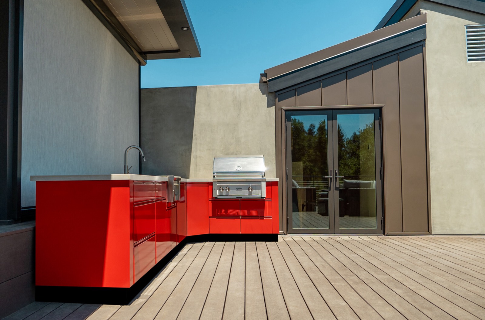 Red L-shaped outdoor kitchen on a rooftop deck