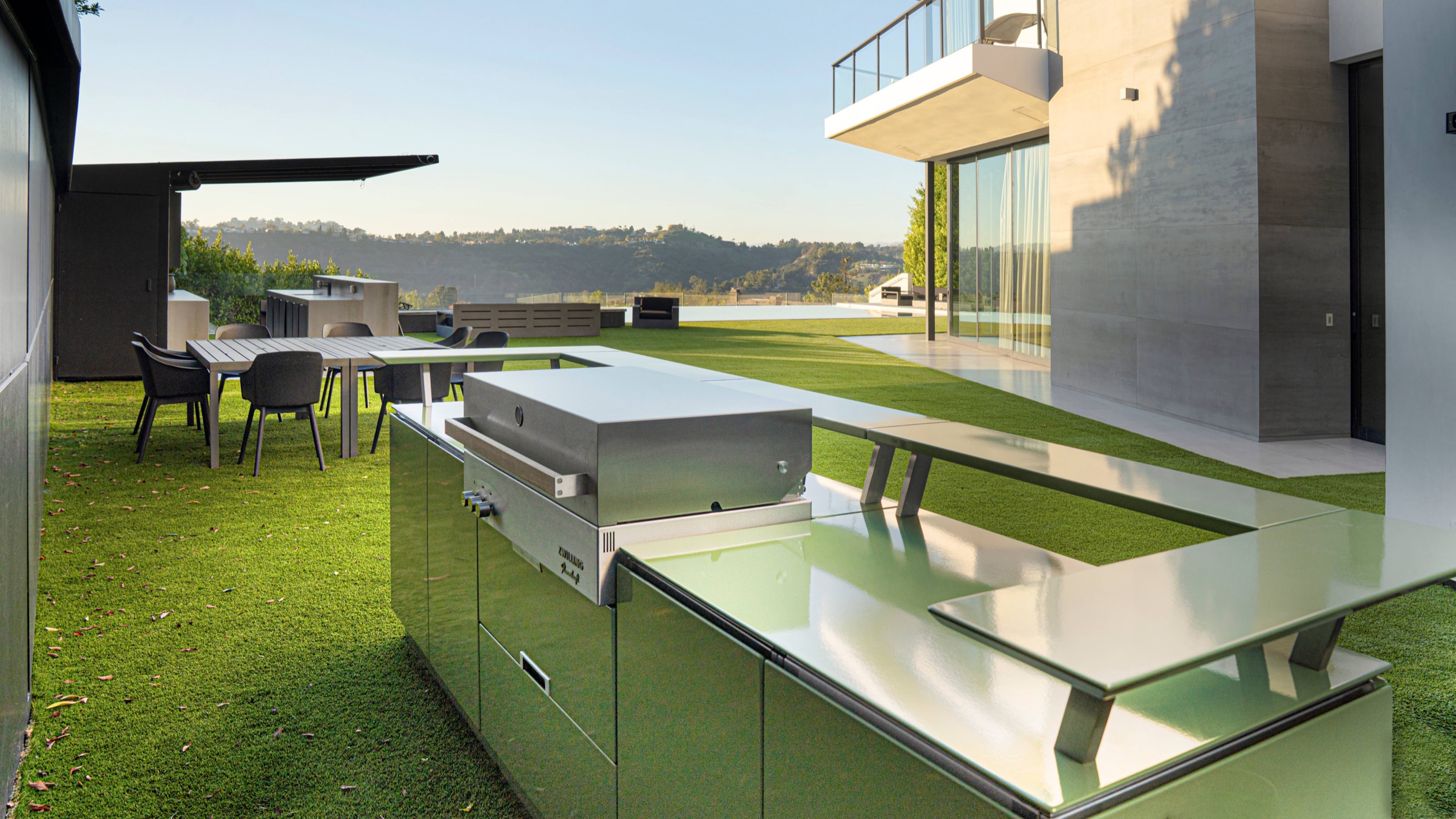 Stainless outdoor kitchen on a lawn with foothills behind